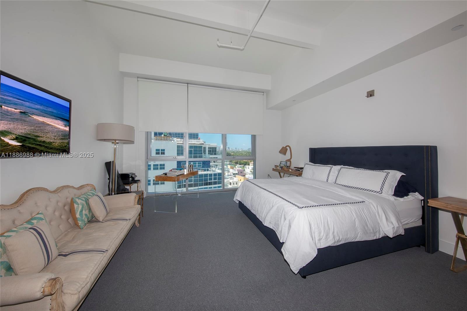 201 Aqua Avenue, Unit 1004 Miami Beach, FL 33141 - Photo 5 of 7 a bedroom with a bed couch and a flat screen tv