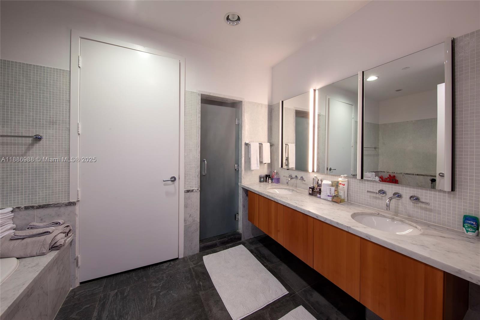 201 Aqua Avenue, Unit 1004 Miami Beach, FL 33141 - Photo 7 of 7 a bathroom with a double vanity sink and mirror