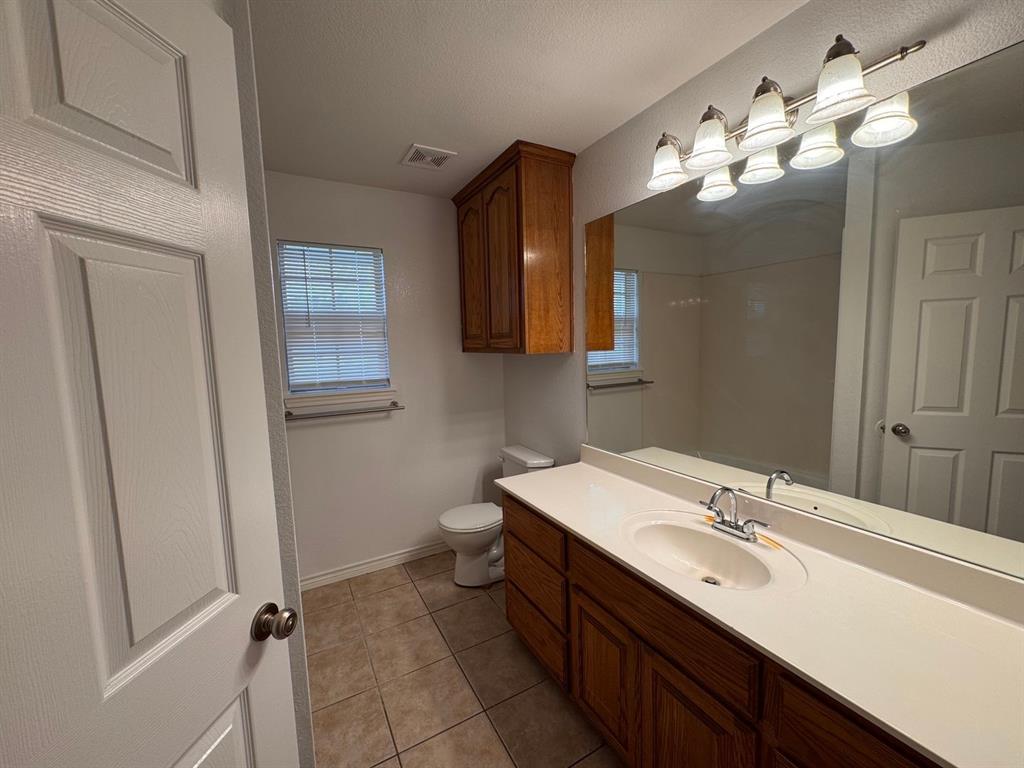 158 Codybug Road Abilene, TX 79602 - Photo 12 of 21 a bathroom with a double vanity sink mirror and toilet