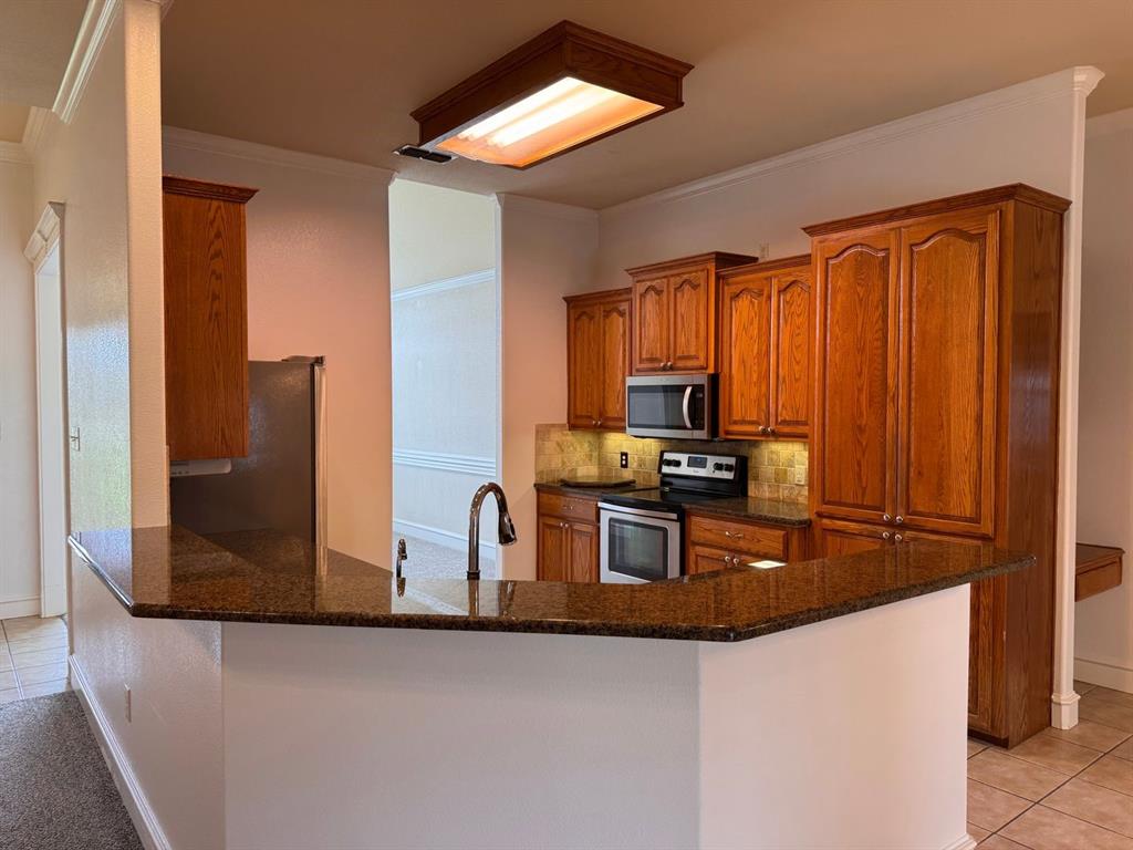 158 Codybug Road Abilene, TX 79602 - Photo 14 of 21 a kitchen with stainless steel appliances granite countertop a refrigerator a stove and a sink with wooden floor