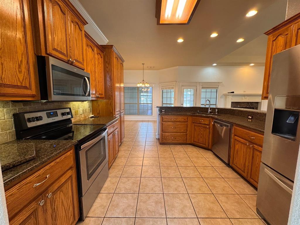 158 Codybug Road Abilene, TX 79602 - Photo 16 of 21 a kitchen with stainless steel appliances granite countertop a stove a sink and a microwave