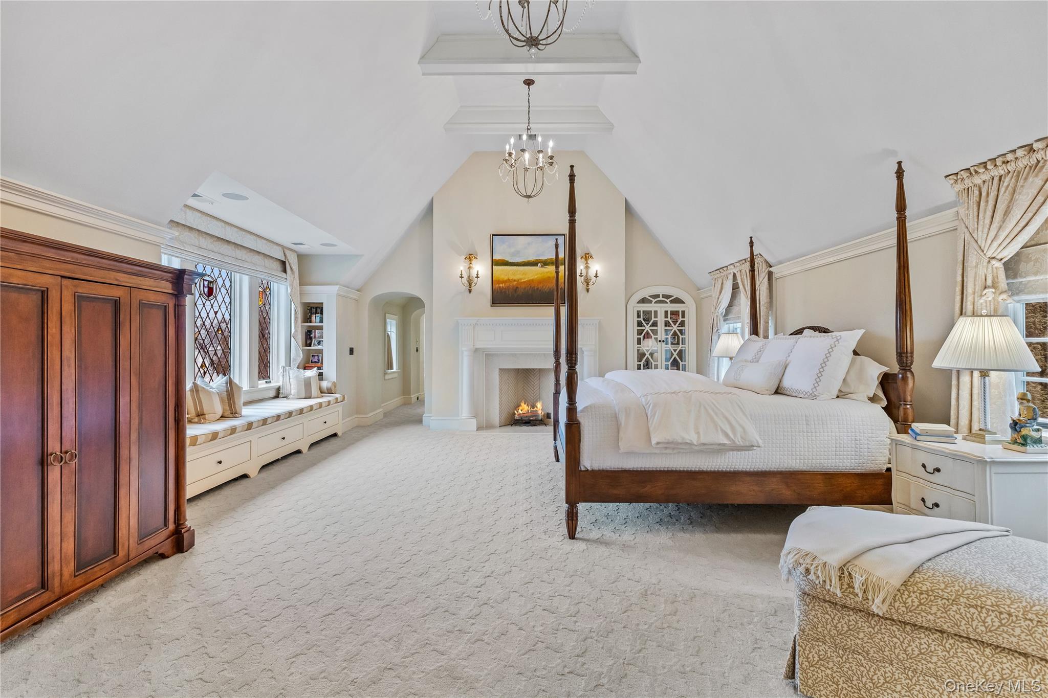 19 Park Drive South Rye, NY 10580 - Photo 22 of 42 Master bedroom featuring light colored carpet, a chandelier, a fireplace, and beamed ceiling.