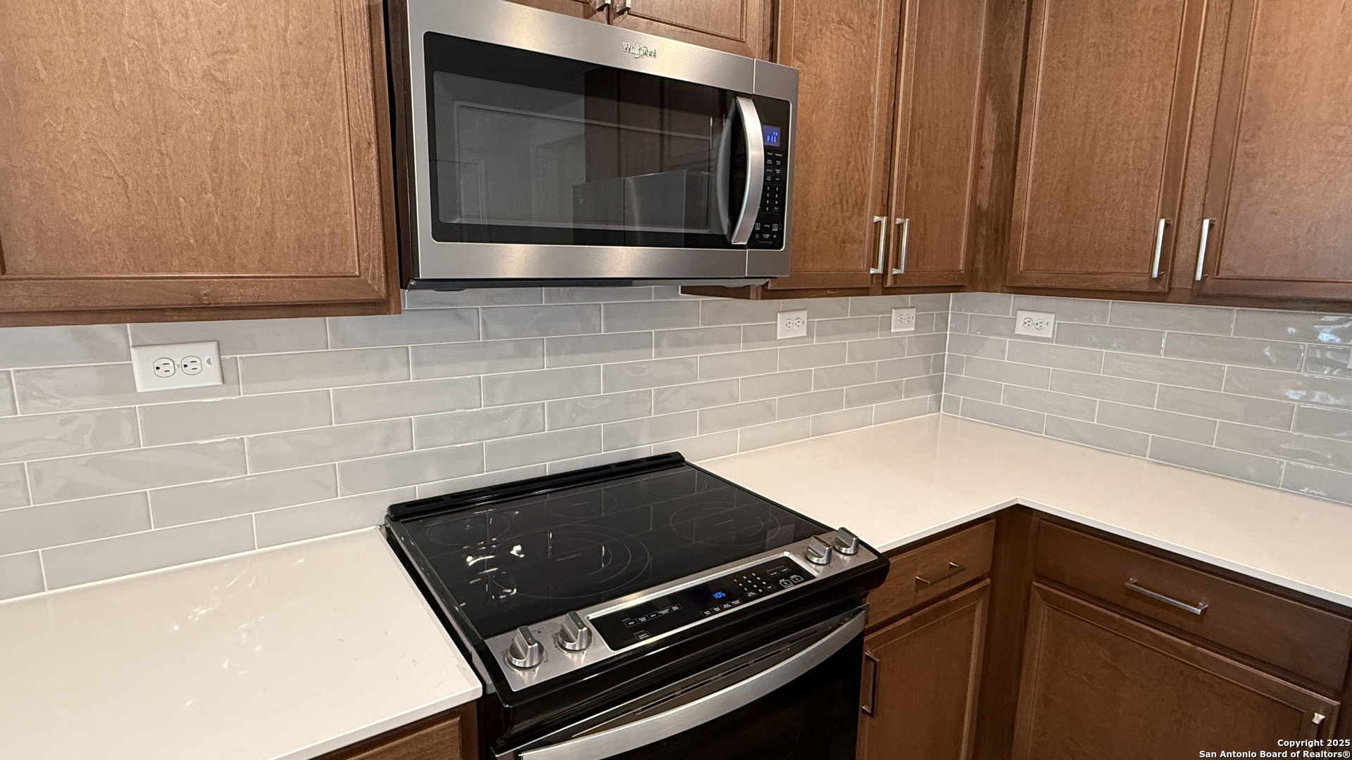 3560 Under Par San Antonio, TX 78245 - Photo 5 of 27 a kitchen with granite countertop white cabinets and black appliances