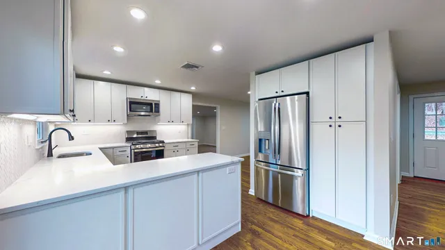 a kitchen with stainless steel appliances granite countertop a refrigerator stove and sink
