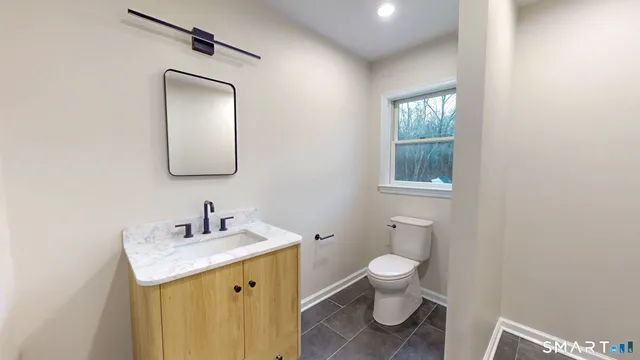 a bathroom with a toilet sink and mirror