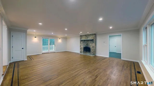 a view of empty room with wooden floor and fireplace