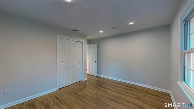 a view of an empty room with wooden floor
