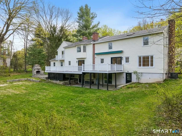 a view of a house with a big yard and large trees