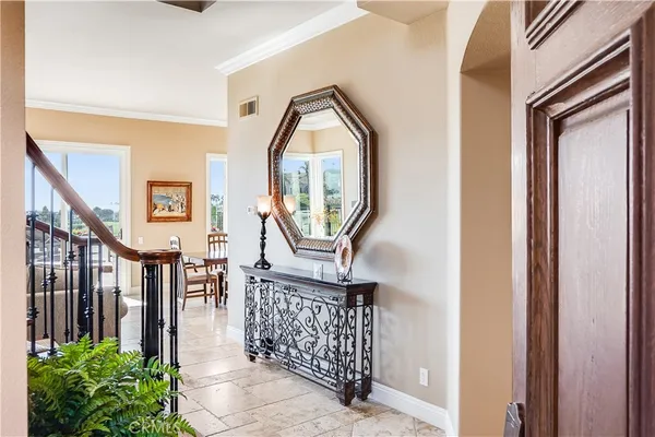 a view of staircase with railing and a chandelier