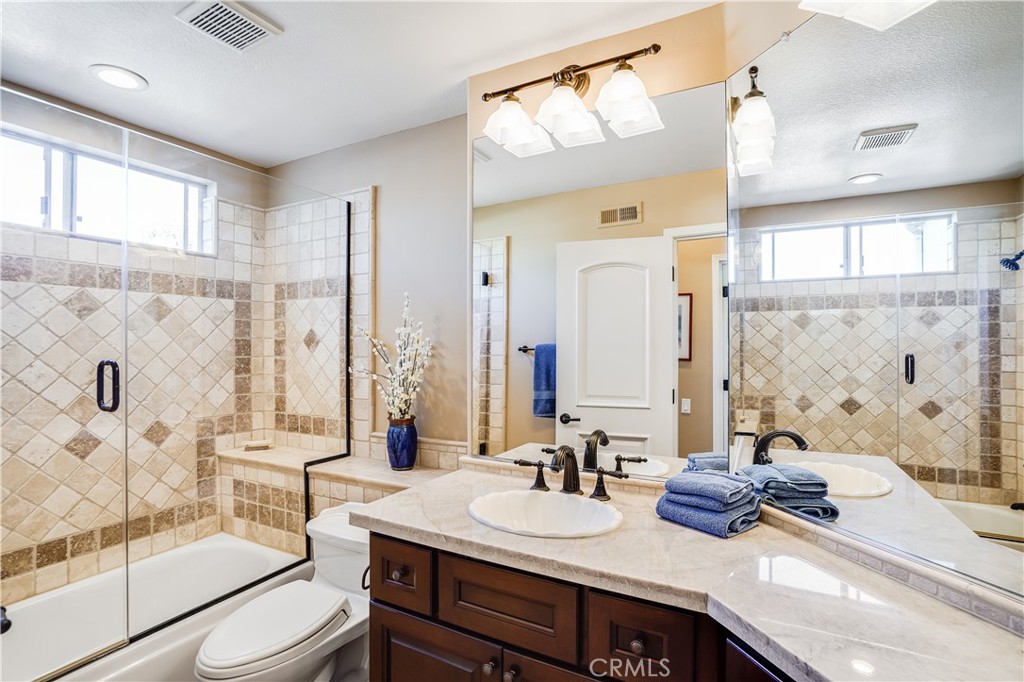 6 Marquesa Dana Point, CA 92629 - Photo 37 of 46 a bathroom with double vanity sinks a toilet a mirror and shower
