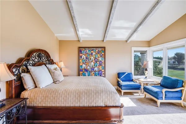 a bedroom with a bed a couch and a large window