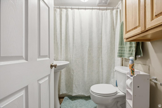 565 East 800 North Logan, UT 84321 - Photo 26 of 27 Pedestal sink with white basin, white toilet, and natural wood cabinetry