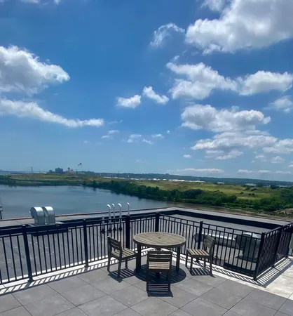 a view of balcony with wooden floor & fence