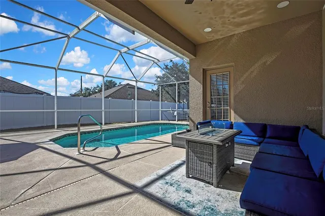 a view of a chair and table in backyard of the house