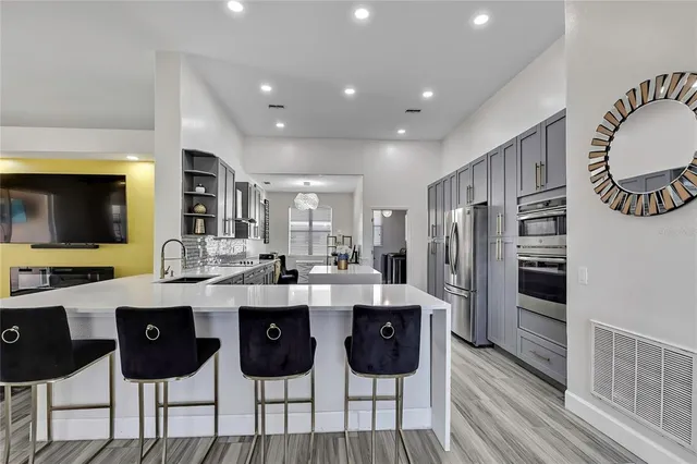 a large kitchen with lots of counter space a sink appliances and a dining table