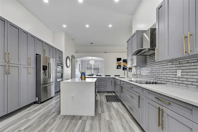 a kitchen with stainless steel appliances granite countertop a refrigerator a sink and a stove