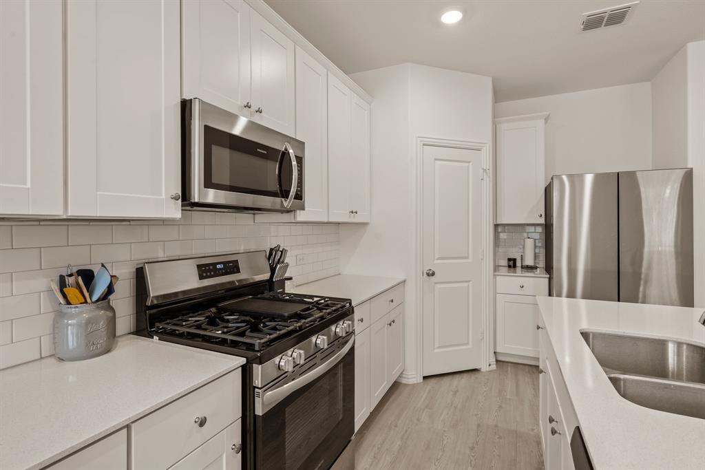 3200 Willow Terrace Lane Anna, TX 75409 - Photo 19 of 40 a kitchen with stainless steel appliances granite countertop a refrigerator and a stove top oven
