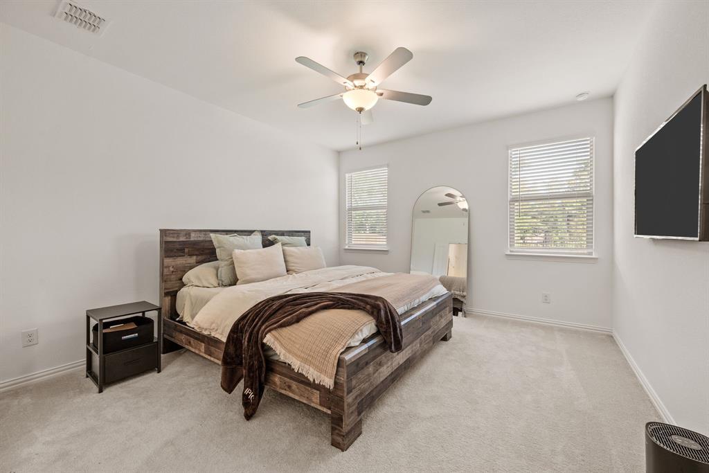 3200 Willow Terrace Lane Anna, TX 75409 - Photo 22 of 40 a spacious bedroom with a bed and a flat screen tv
