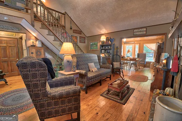 a living room with furniture a piano and wooden floor