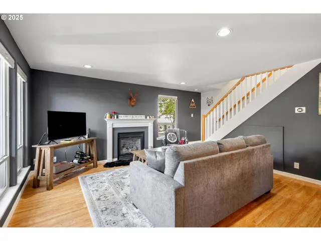 a living room with furniture a flat screen tv and a fireplace