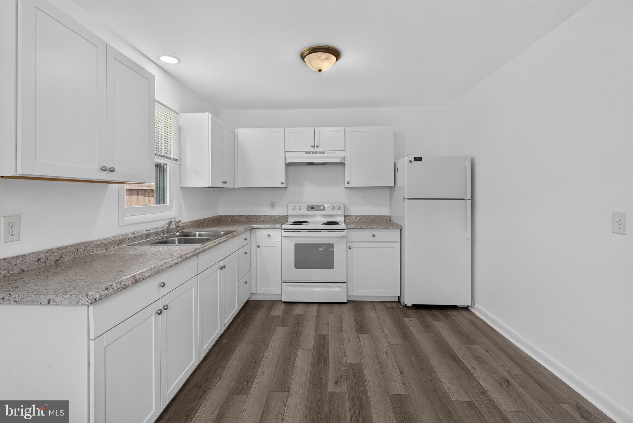 351 Calvert Street Chestertown, MD 21620 - Photo 6 of 19 a kitchen with granite countertop white cabinets and white appliances