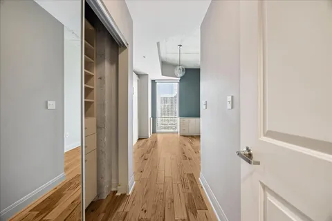 a view of an empty room with wooden floor and a window