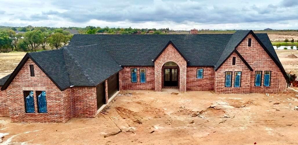 a view of a house with wooden fence next to a yard