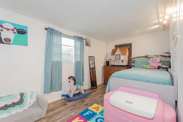 a bedroom with a bed and wooden floor