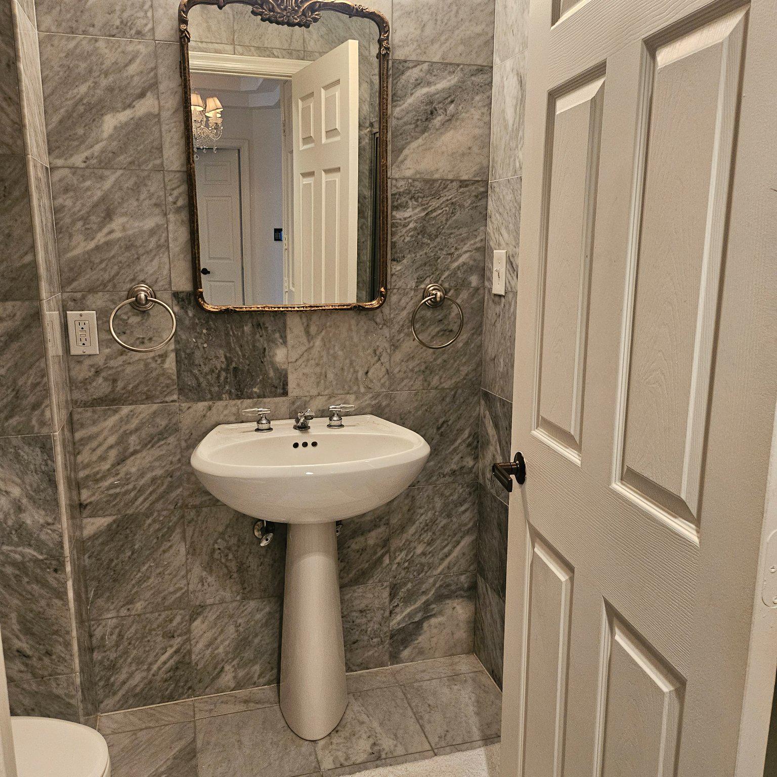3801 Canterbury Road, Unit 611 Baltimore, MD 21218 - Photo 12 of 32 a bathroom with a sink a toilet and mirror