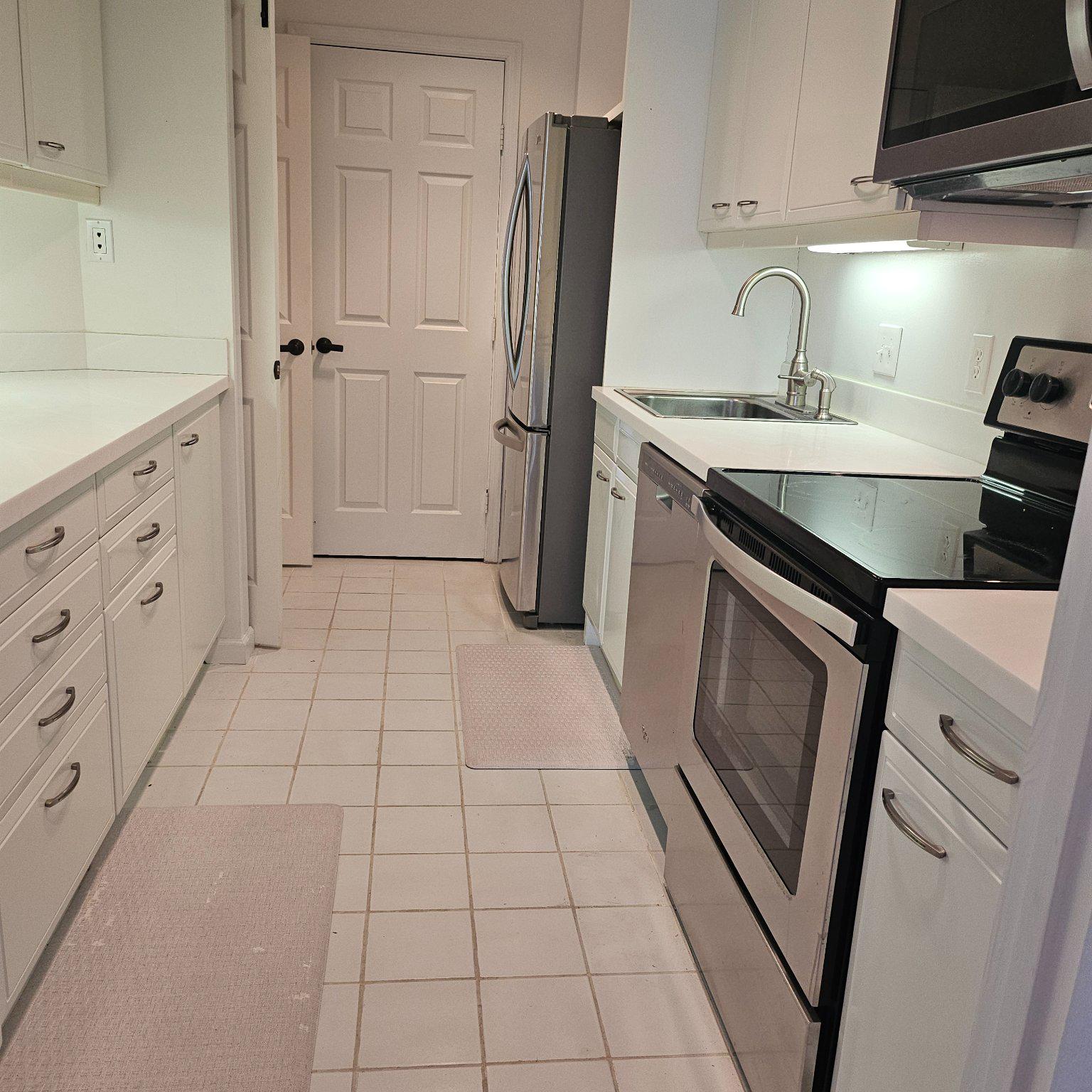 3801 Canterbury Road, Unit 611 Baltimore, MD 21218 - Photo 18 of 32 a kitchen with a sink a refrigerator and cabinets