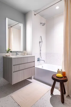 a bathroom with a tub sink and mirror
