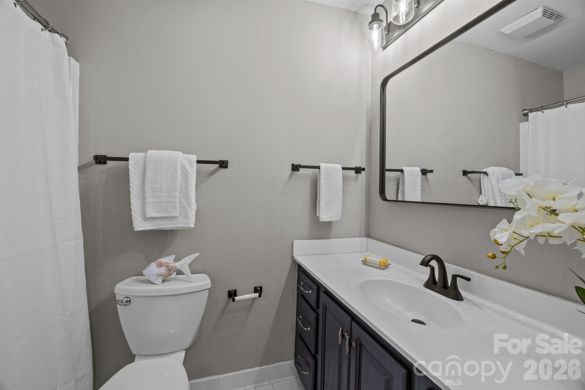 416 Queens Road, Unit 19 Charlotte, NC 28207 - Photo 17 of 24 a bathroom with a sink mirror and toilet