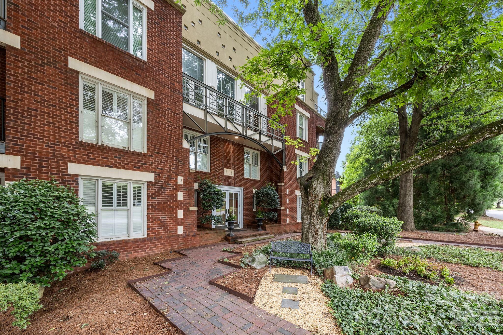 416 Queens Road, Unit 19 Charlotte, NC 28207 - Photo 20 of 23 a view of a building with a yard