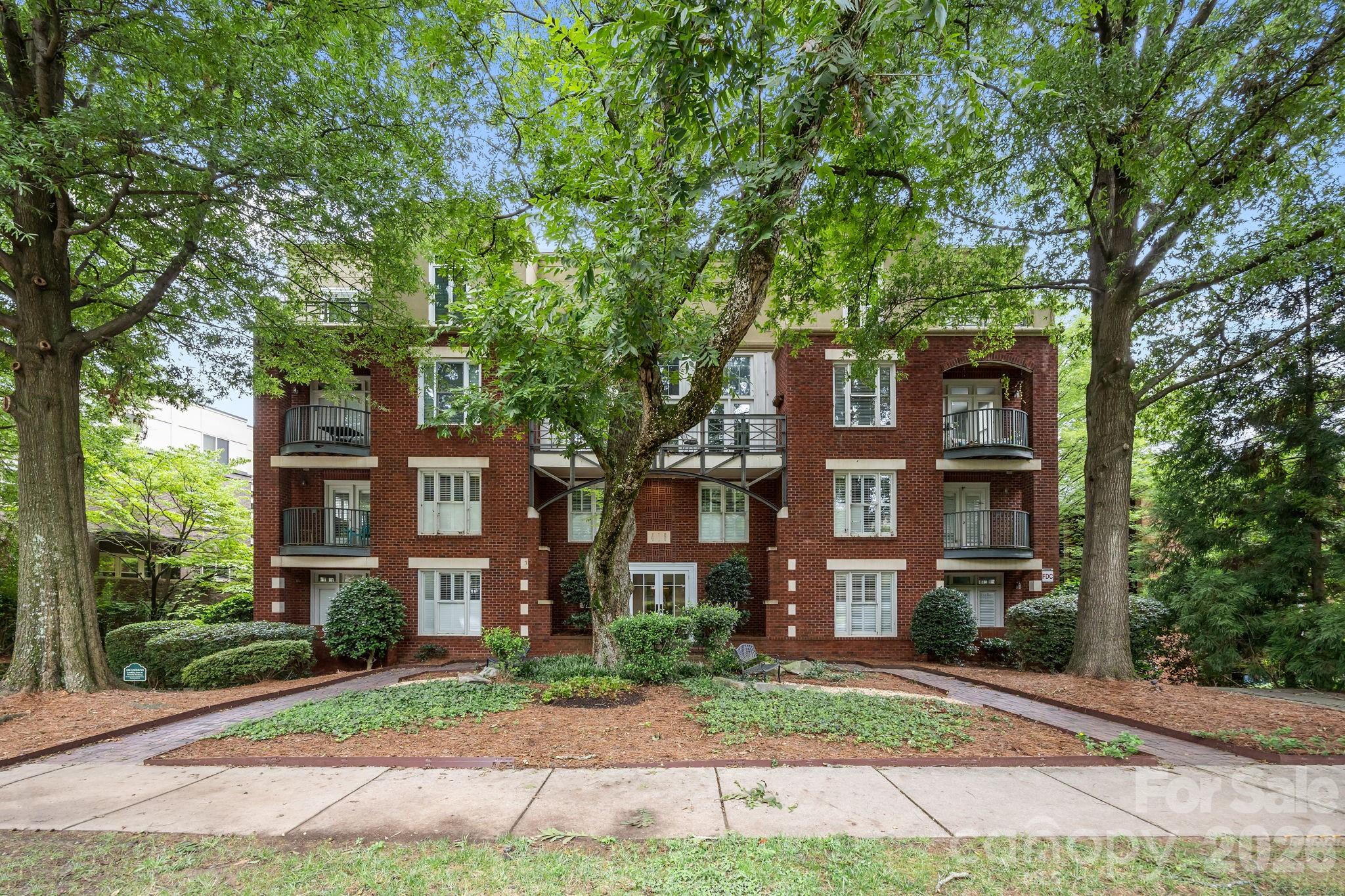 416 Queens Road, Unit 19 Charlotte, NC 28207 - Photo 23 of 24 front view of a brick house next to a yard