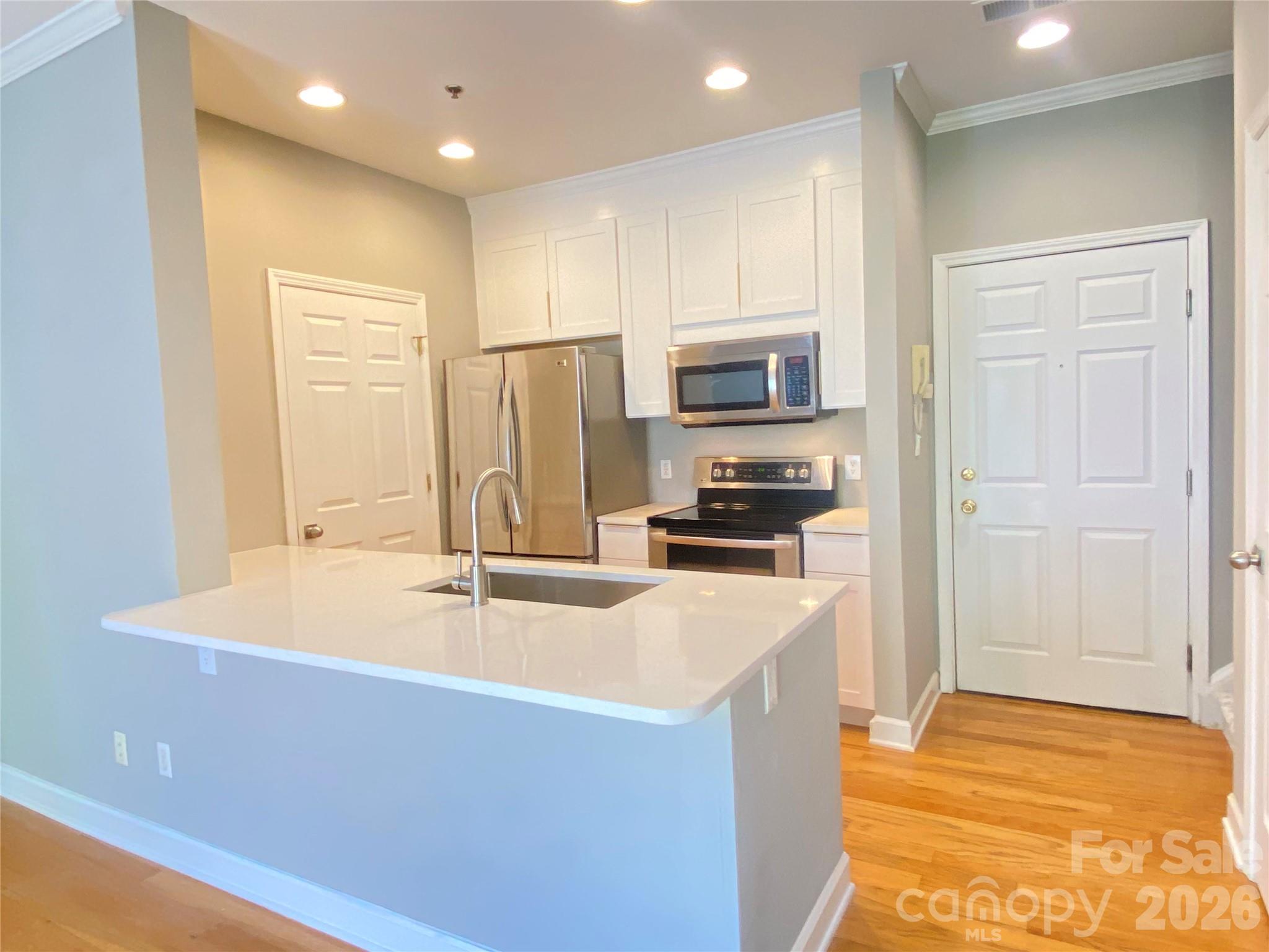 416 Queens Road, Unit 19 Charlotte, NC 28207 - Photo 5 of 23 a kitchen with stainless steel appliances granite countertop a sink and a refrigerator