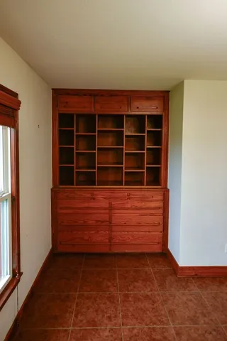 an empty room with windows and fireplace