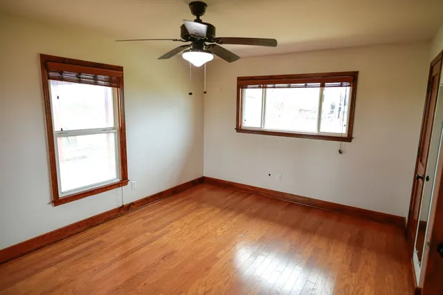 an empty room with wooden floor and closet
