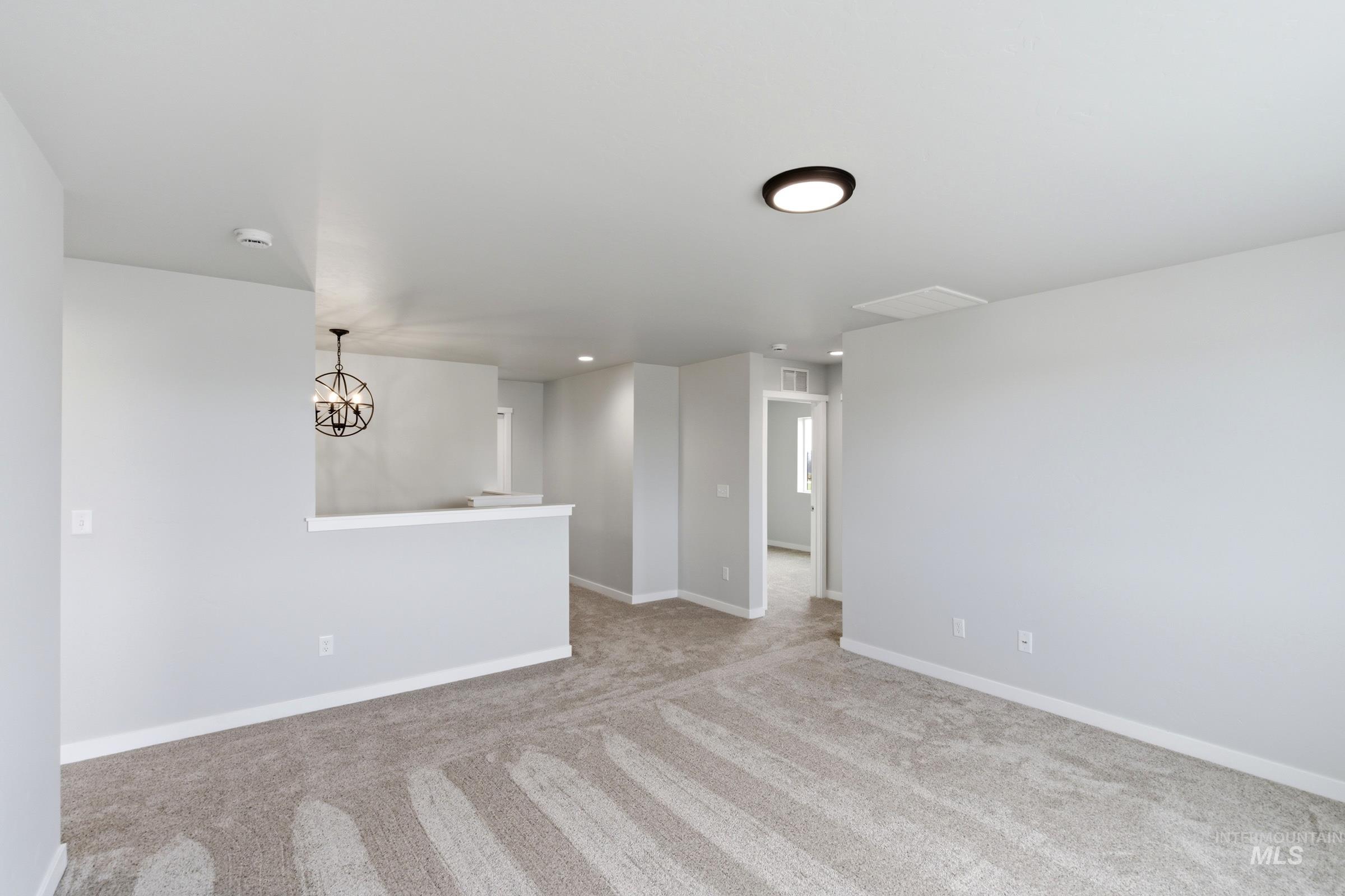 16558 Dunning Way Caldwell, ID 83607 - Photo 19 of 35 Open concept room featuring light gray walls, neutral carpet flooring, and white baseboards