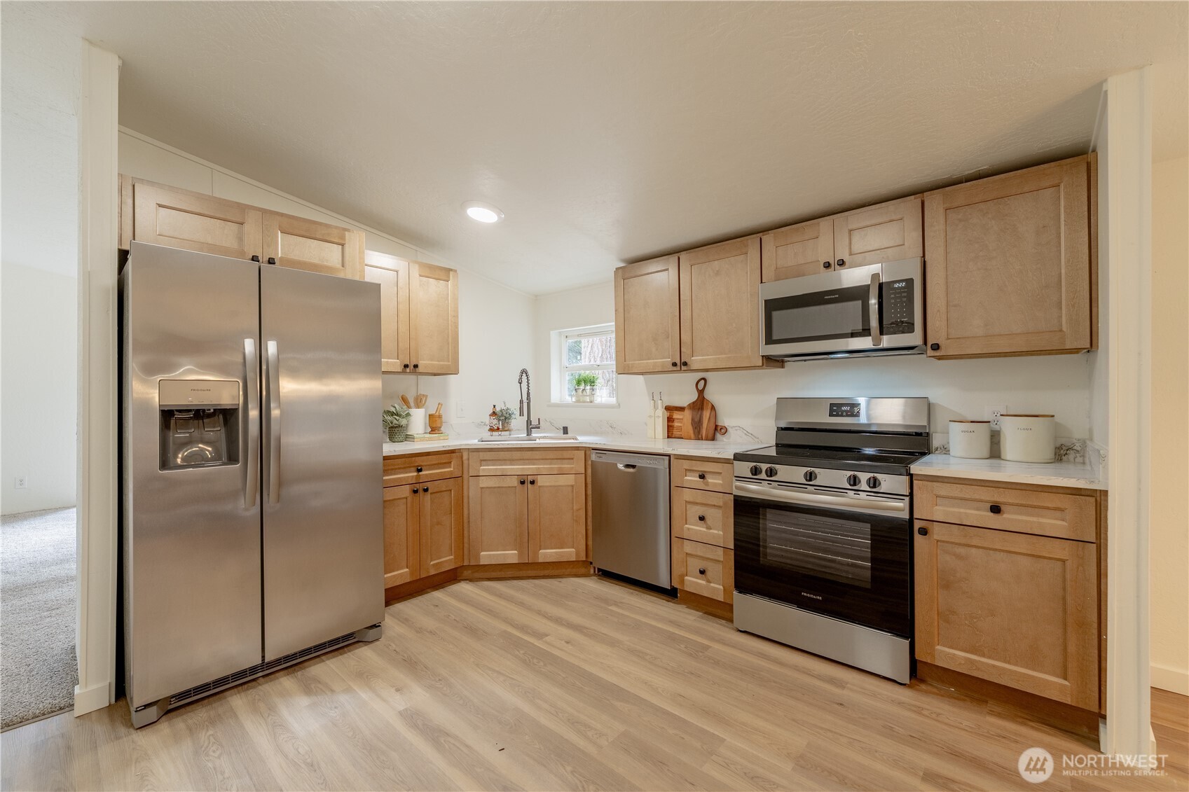 10794 Halloran Road Bow, WA 98232 - Photo 11 of 39 a kitchen with stainless steel appliances granite countertop a refrigerator a stove top oven a sink and dishwasher with wooden floor