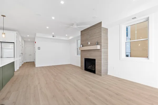 a large kitchen with stainless steel appliances kitchen island a large counter top and a wooden floors