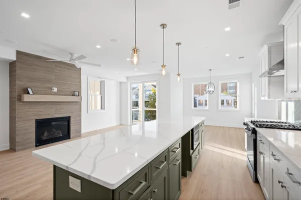 an empty room with a chandelier fan and windows