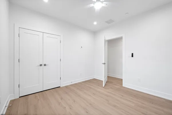 an empty room with a window and ceiling fan