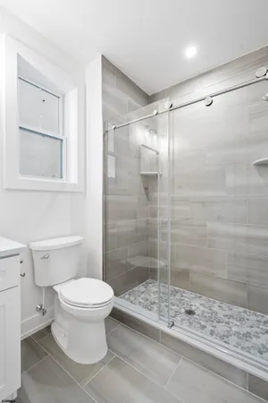 a bathroom with a sink toilet a mirror and shower