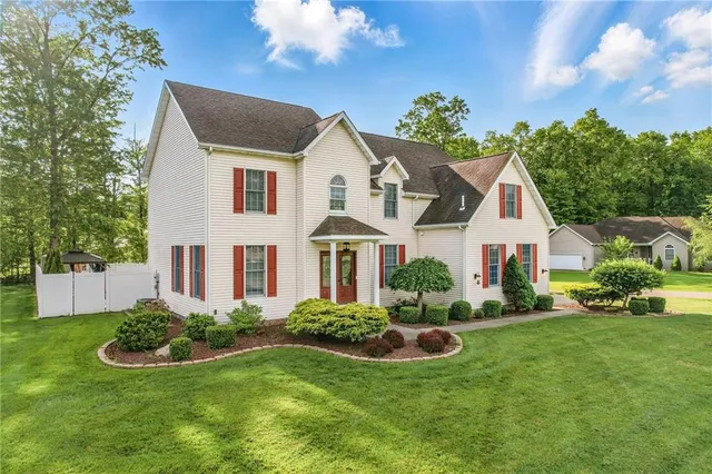 a front view of a house with a garden and plants