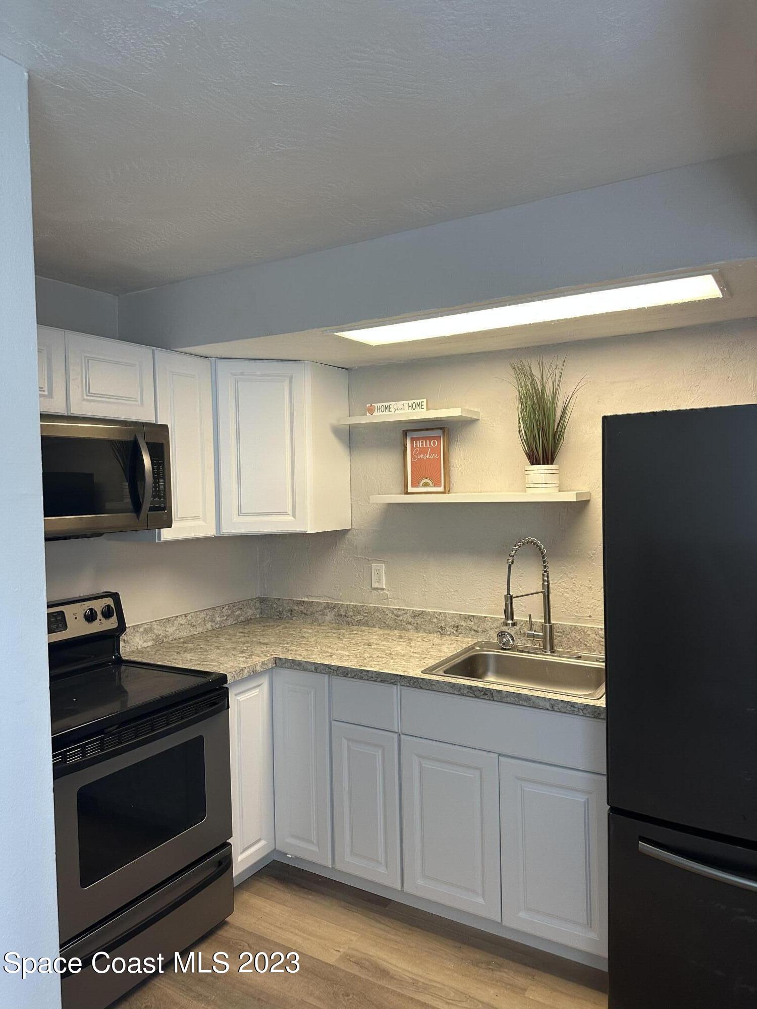 23 Elton Street, Unit 23 Melbourne, FL 32935 - Photo 2 of 4 a kitchen with granite countertop a sink and cabinets