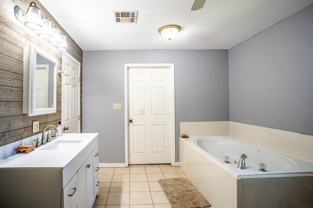 682 Lcr 450 Groesbeck, TX 76642 - Photo 19 of 38 a bathroom with a tub sink and mirror