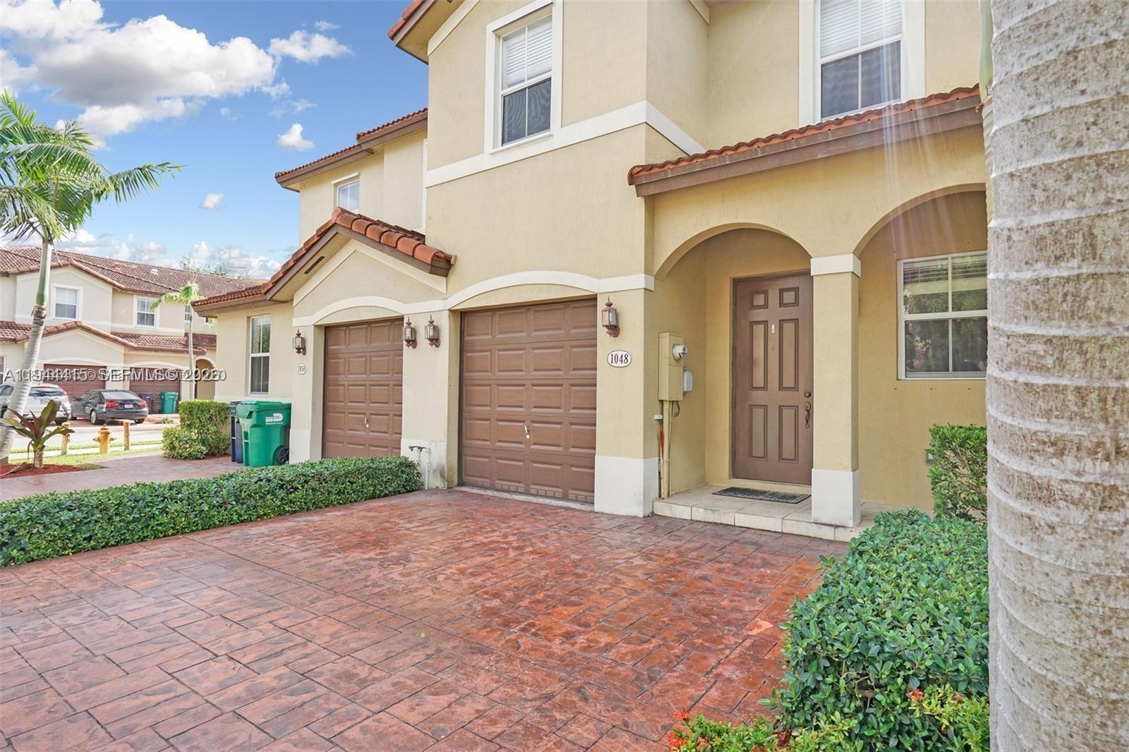 1048 Northeast 208th Street Miami, FL 33179 - Photo 2 of 36 a front view of a house with garden