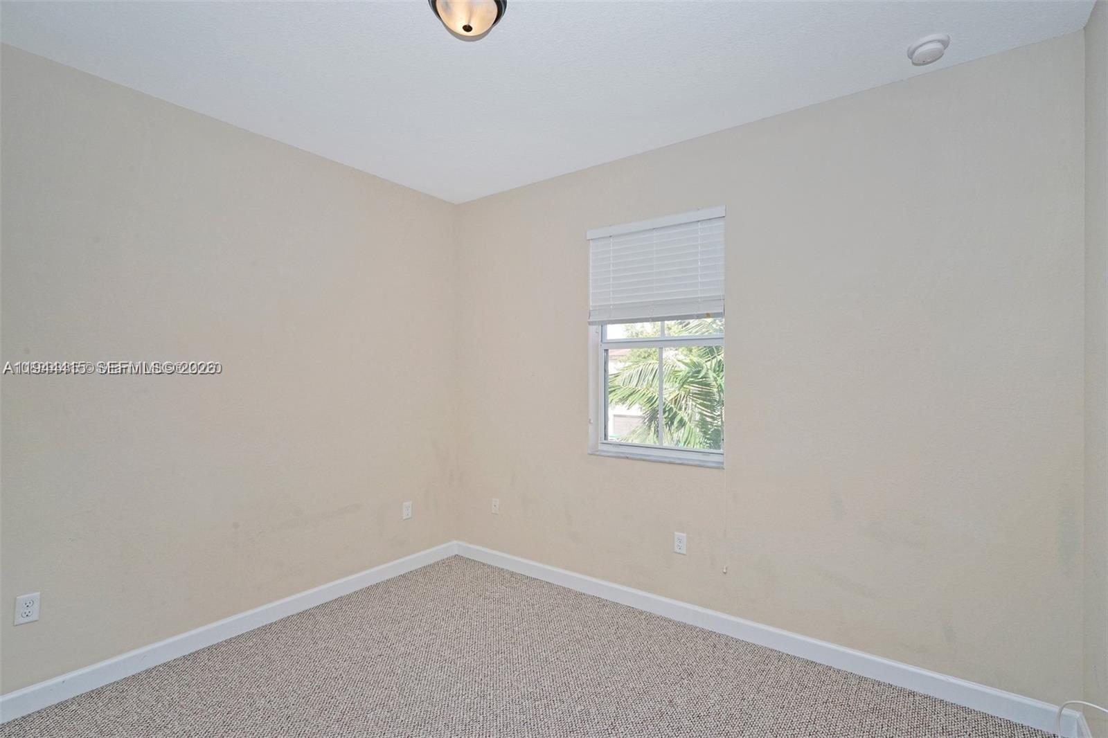 1048 Northeast 208th Street Miami, FL 33179 - Photo 27 of 36 an empty room with windows