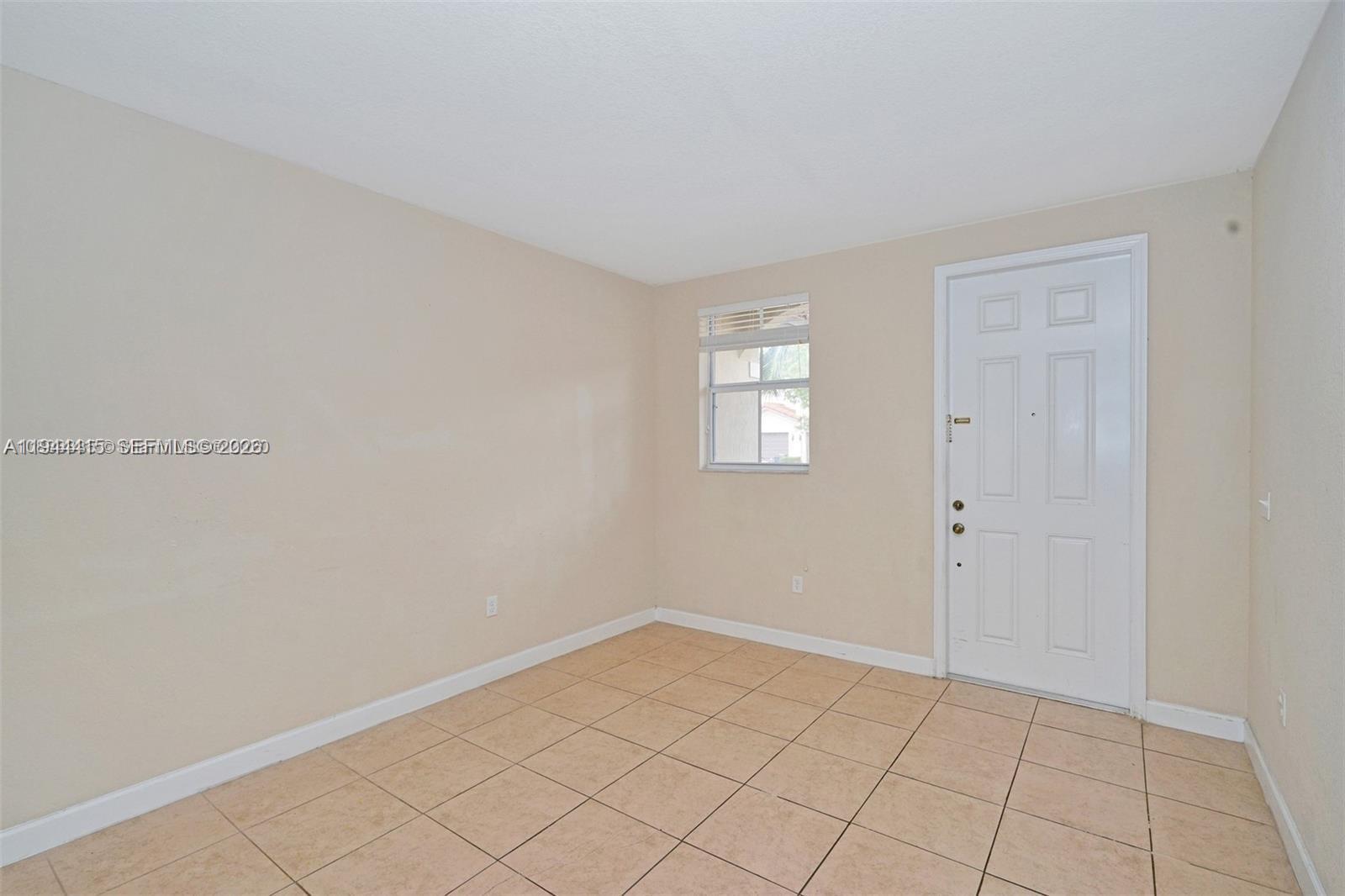 1048 Northeast 208th Street Miami, FL 33179 - Photo 9 of 36 a view of an empty room and window