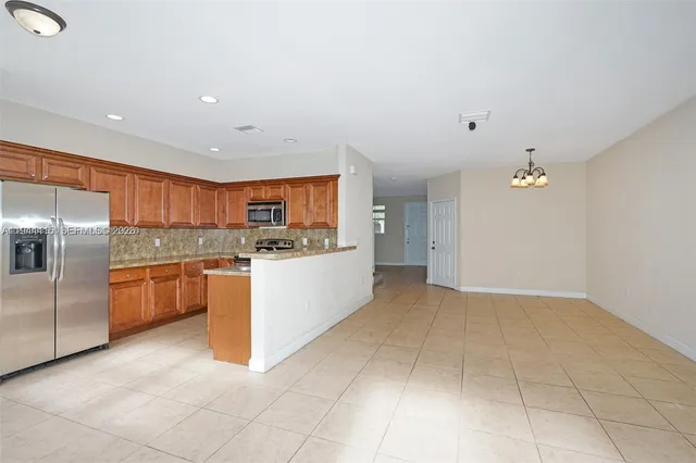 a large kitchen with cabinets and stainless steel appliances